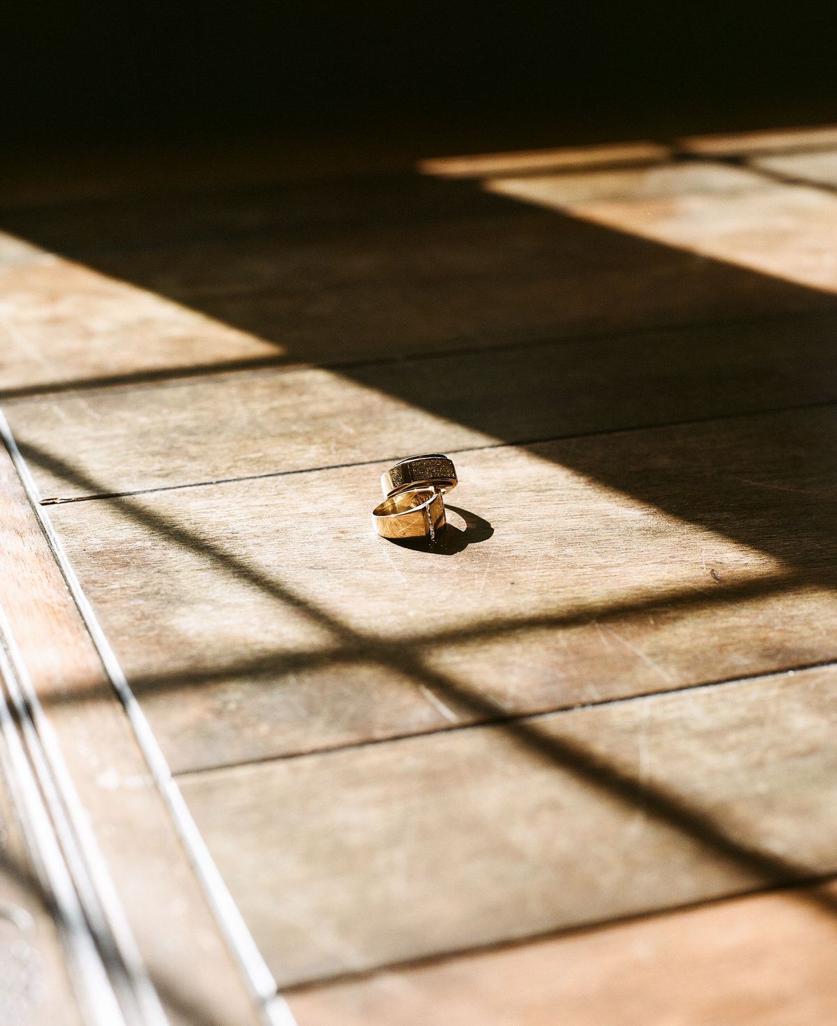 Two wedding rings with sunlight shining on them through window panes