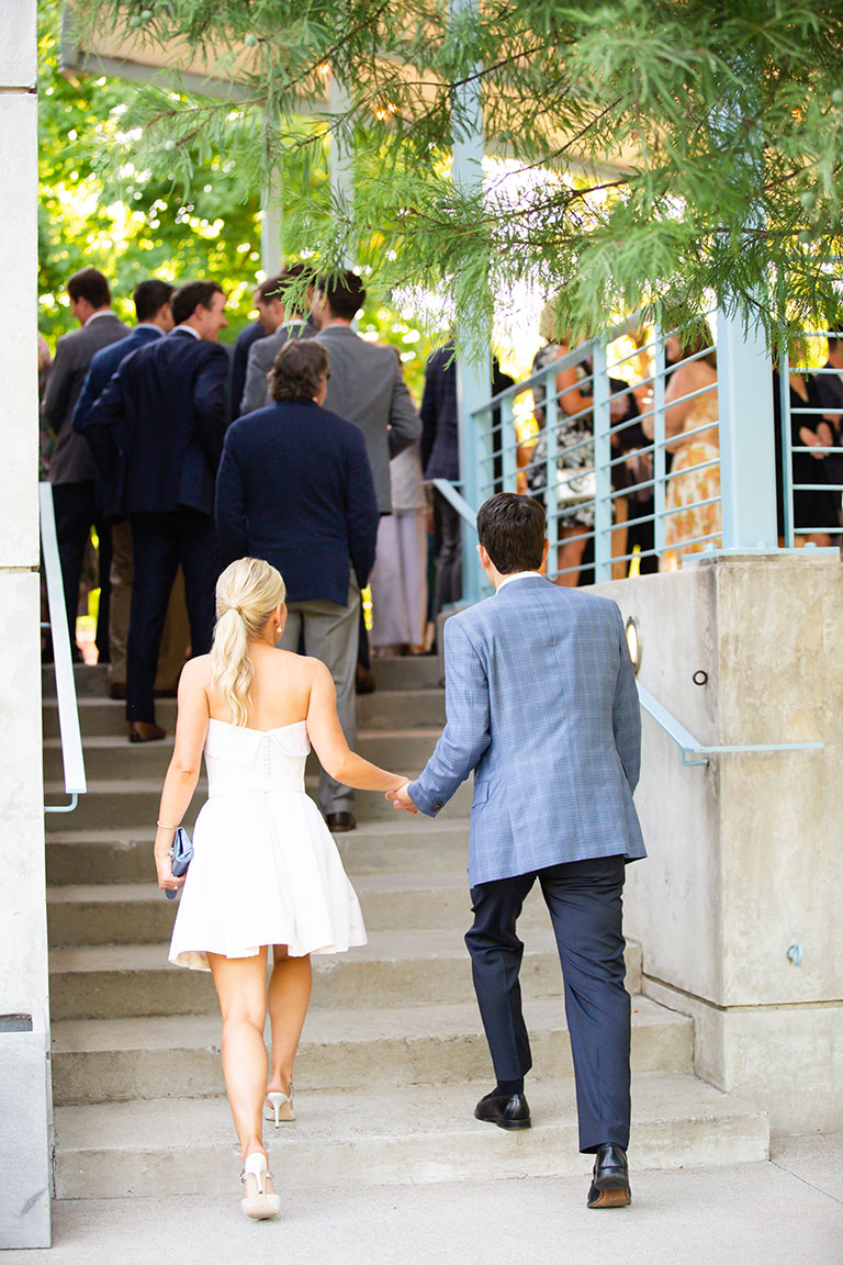 Bride and groom walking up stairs to rehearsal dinner at Ruby