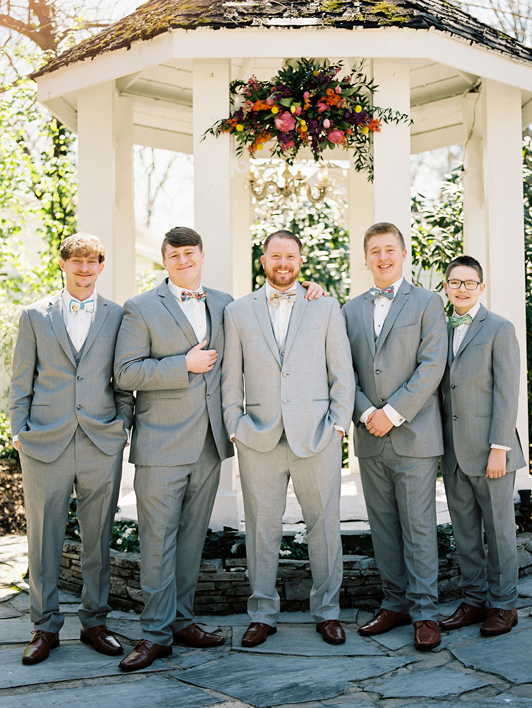 Groom Standing with Groomsmen in Gray Suits