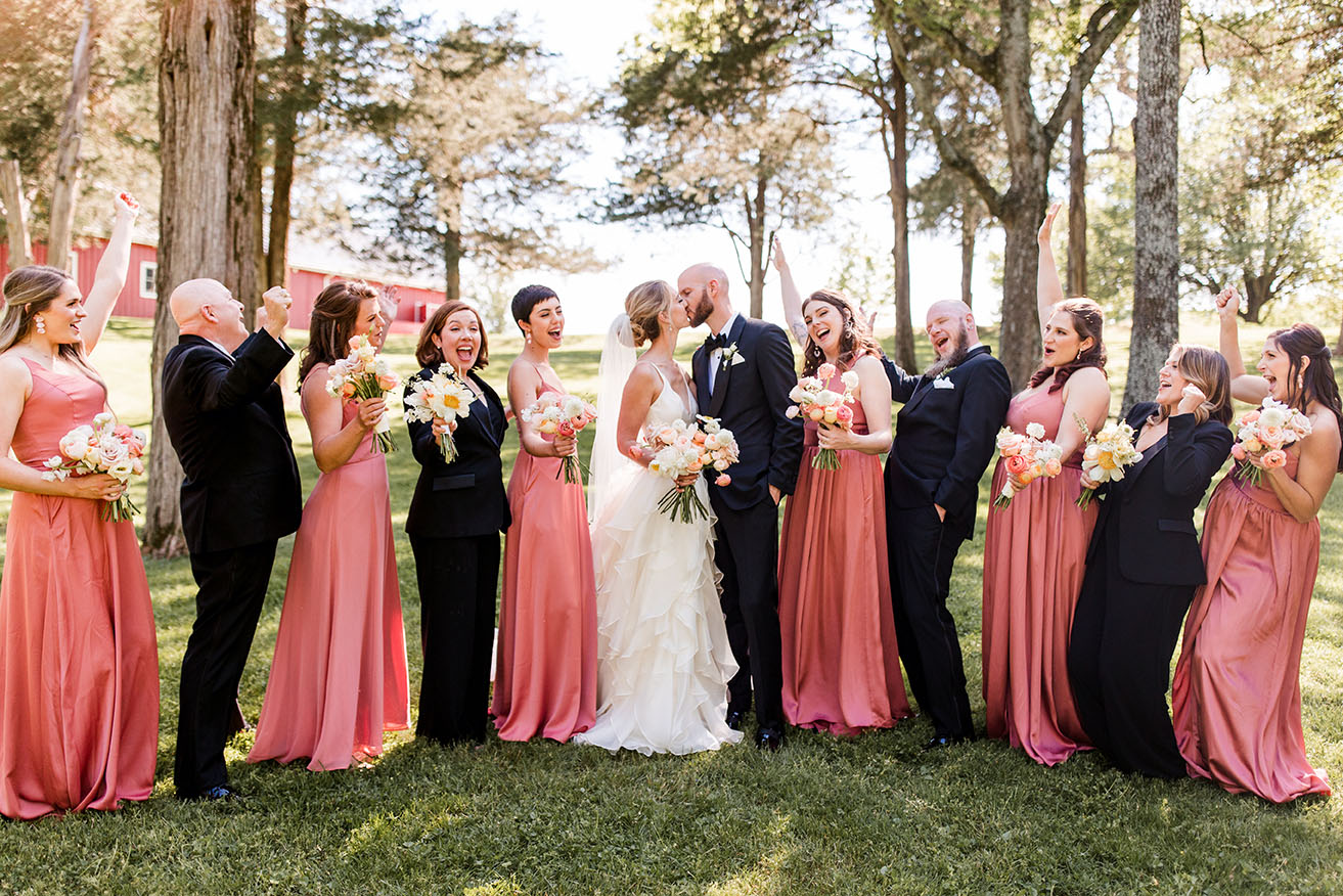 Colleen and Kevyn Kissing Surrounded by Wedding Party