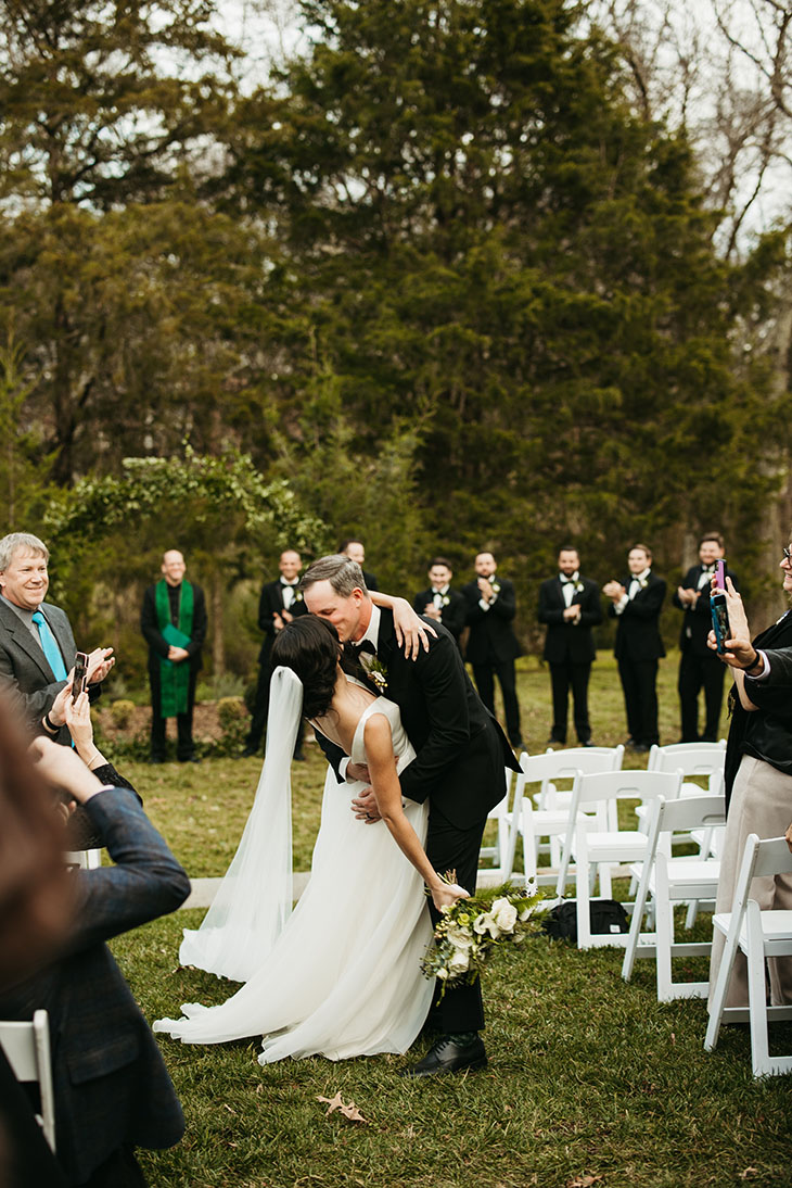 bride and groom kissing during ceremony exit