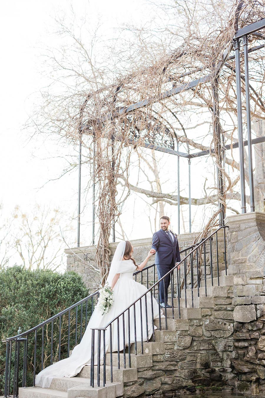 bride and groom holding hands walking up cheekwood steps