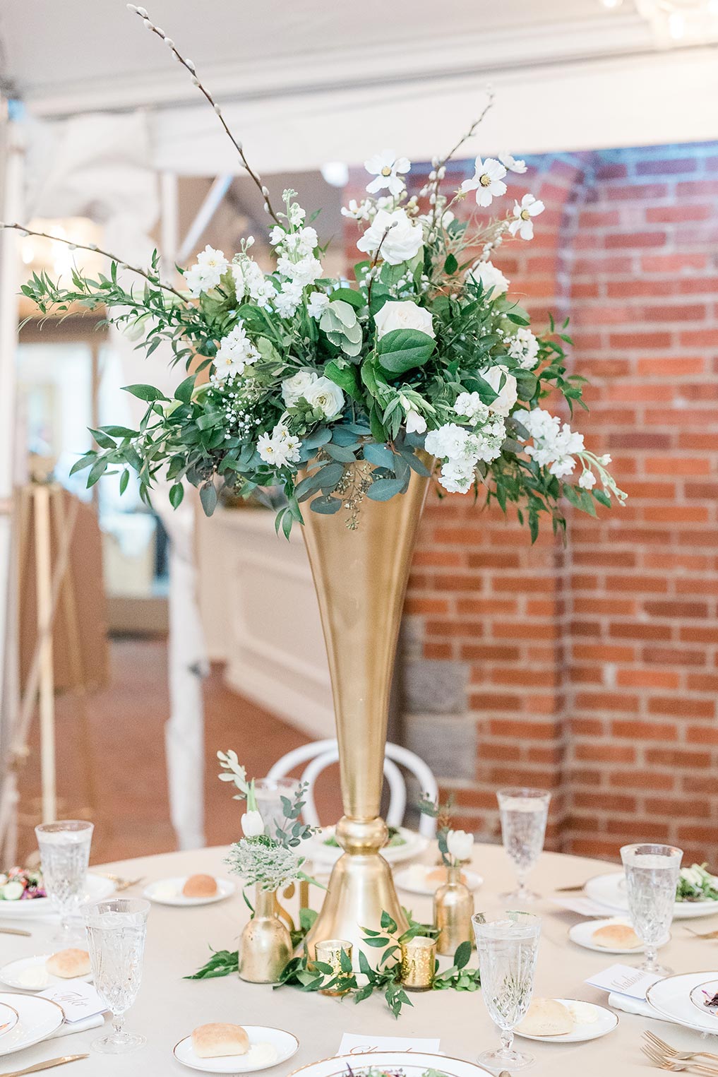 tall gold centerpieces with green and white florals