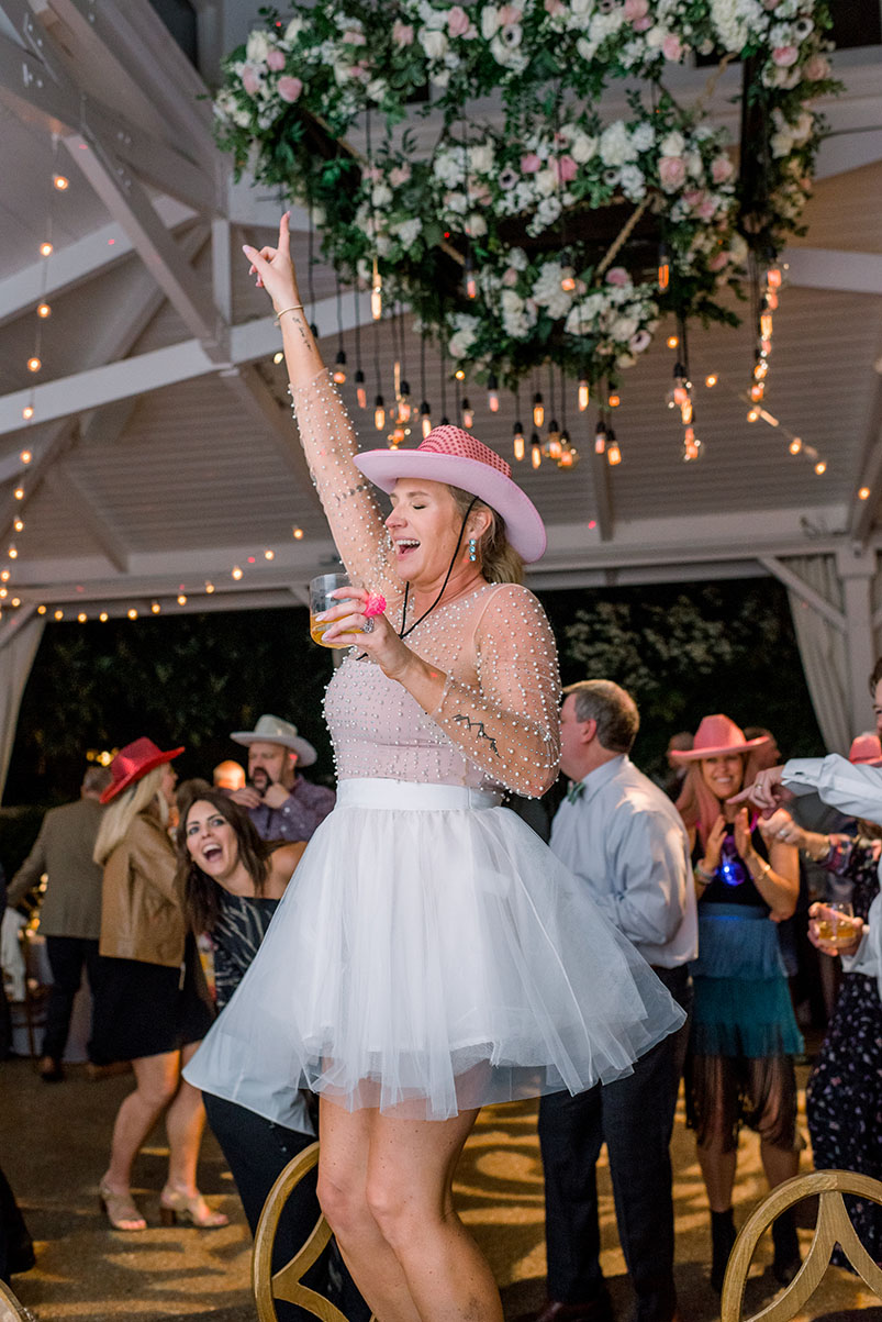 bride dancing in cowgirl hat