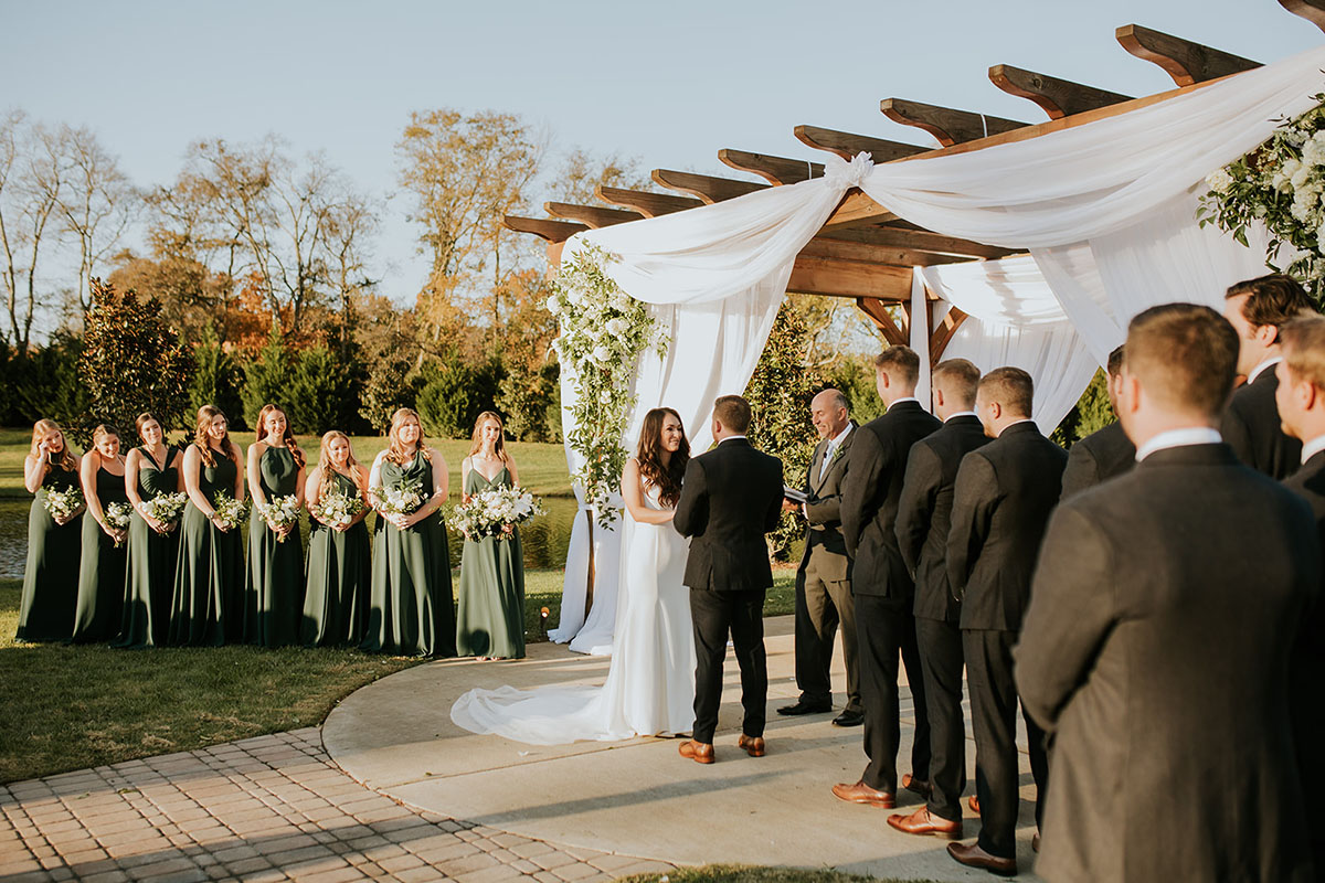 bride and groom standing at alter with wedding party