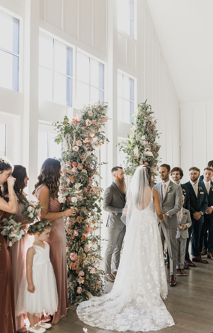 wedding ceremony with floral arch