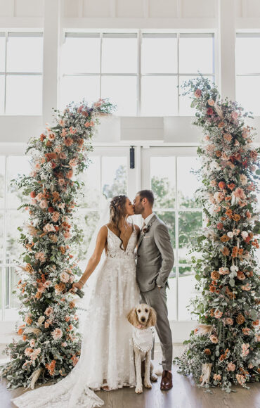 bride and groom with puppy at wedding ceremony