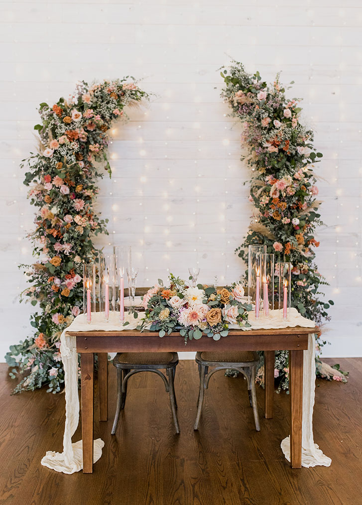 wedding sweetheart table with floral arch