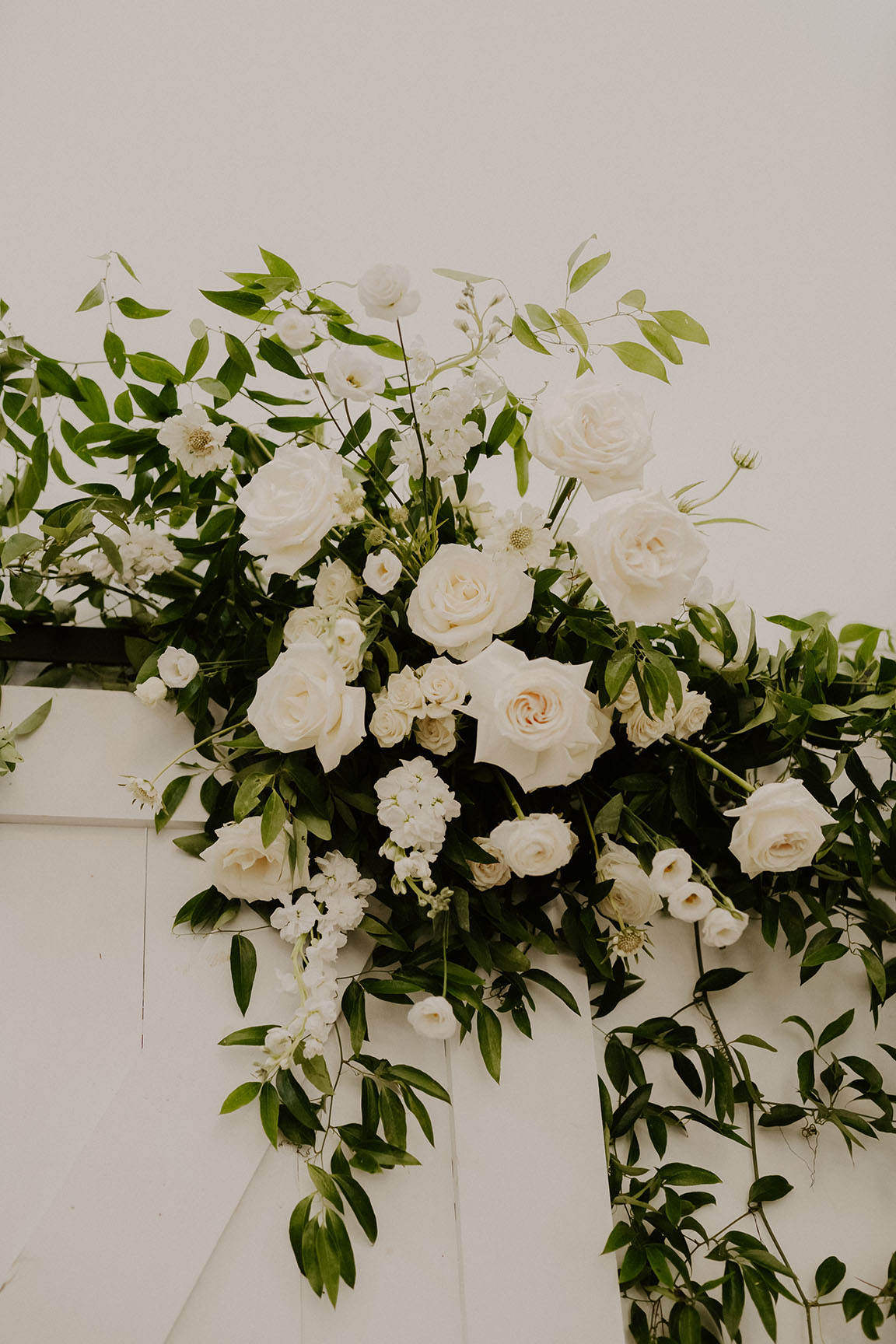 A close-up view of the white floral and greenery arrangement that hung at the end of the aisle