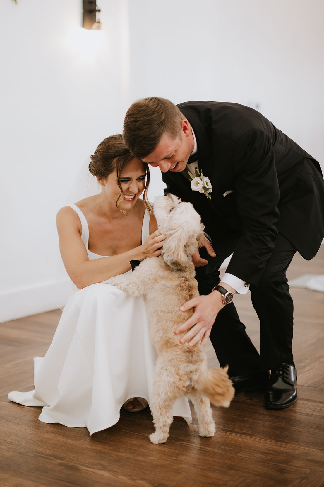 The bride and groom greet their dog just before their wedding ceremony