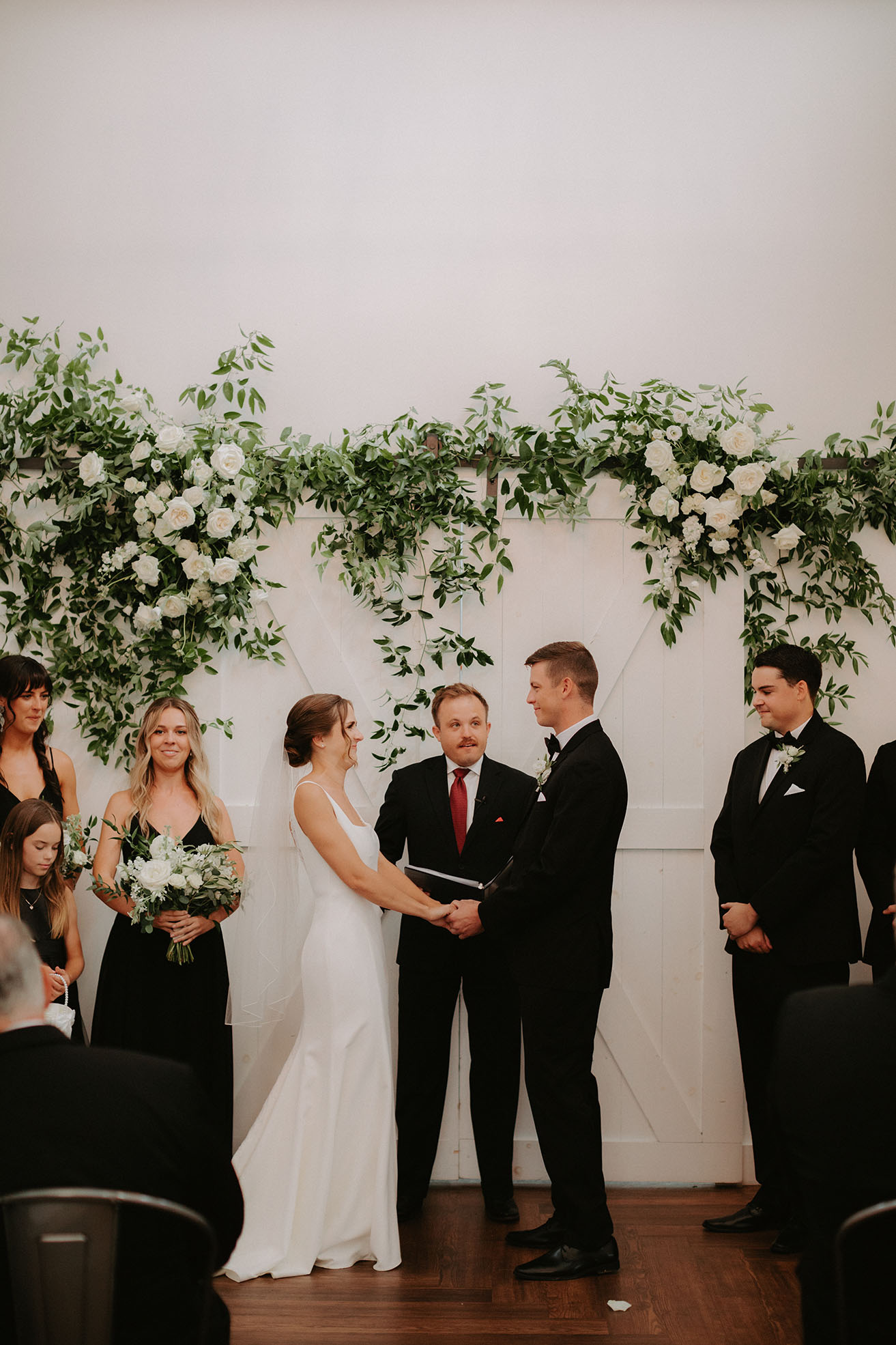 The bride and groom hold hands at the end of their wedding aisle during their wedding ceremony