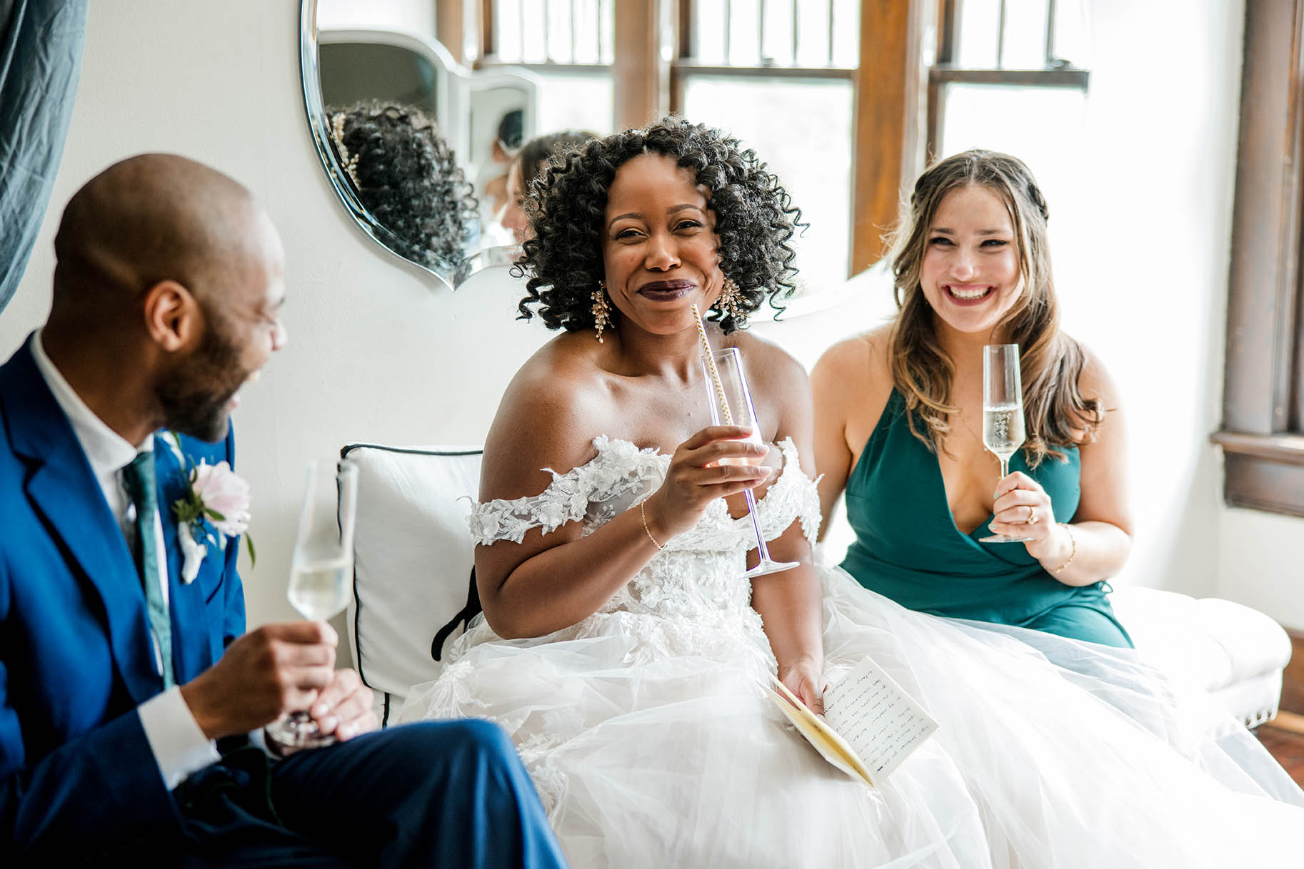 bride and bridal party drinking champagne and getting ready in bridal suite