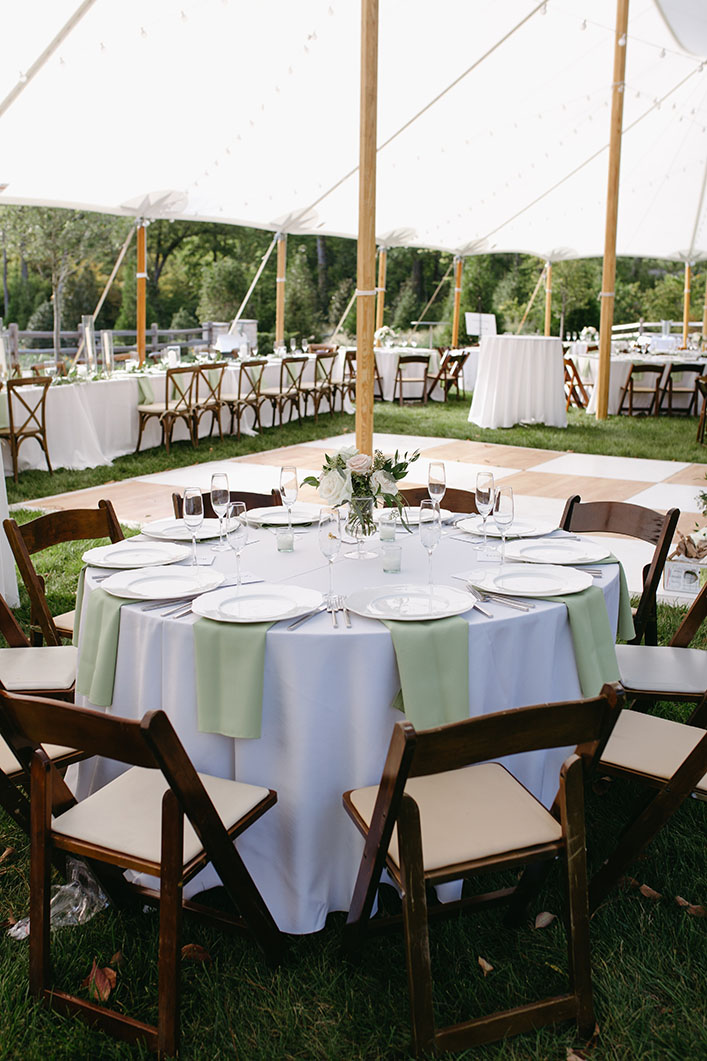 wedding reception decor with sage green napkins and dark brown wooden chairs