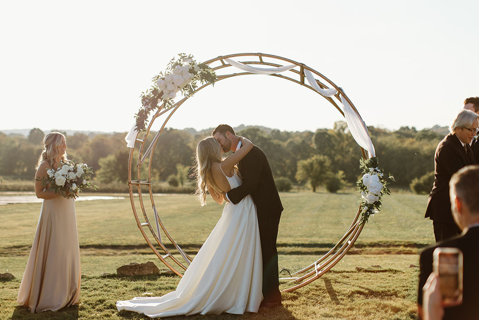 bride and groom kissing at outdoor ceremony