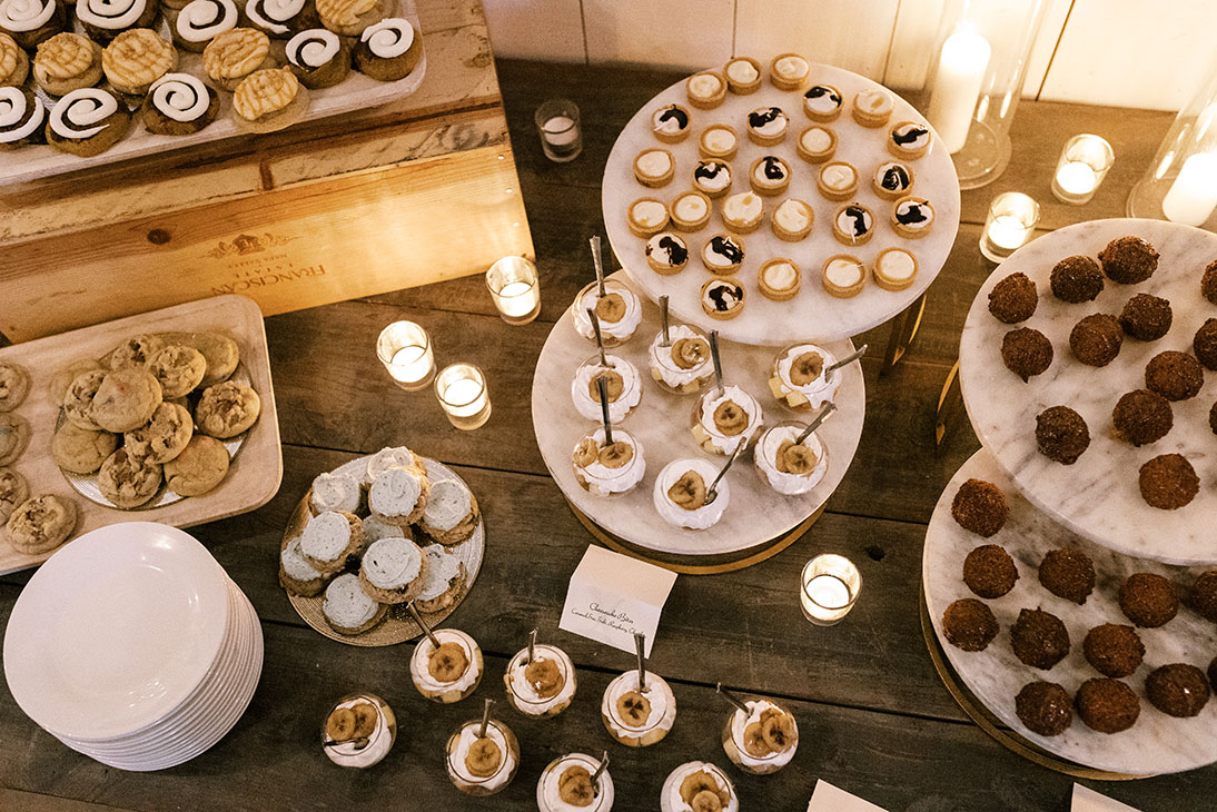 wedding dessert station various desserts displayed on plates and votive candles as decor