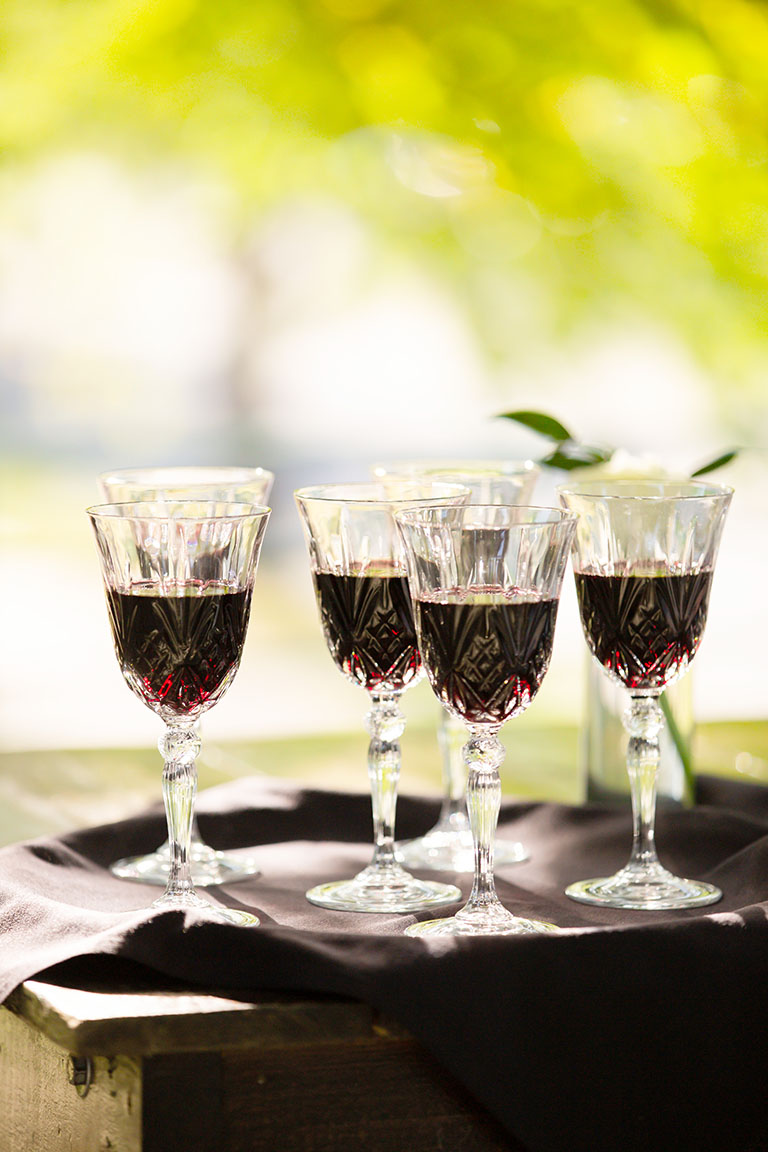 A tray of red wine in textured crystal goblet glassware