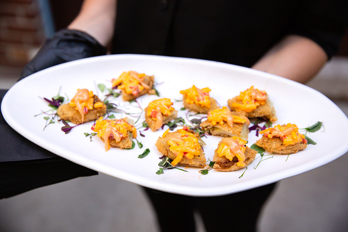 Fried green tomatoes, quartered and served with pimento cheese on top