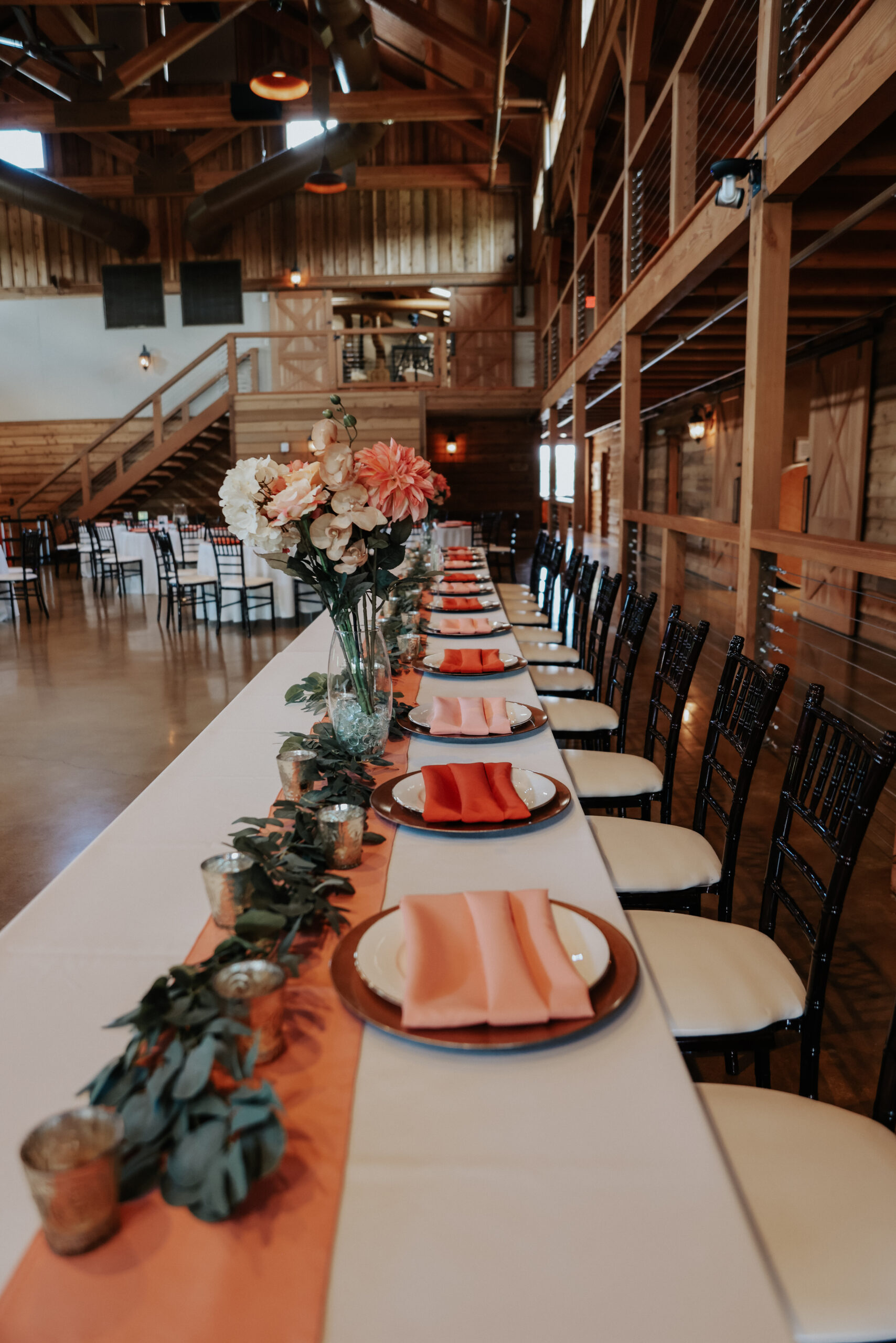 A reception table with coral and peach napkins.