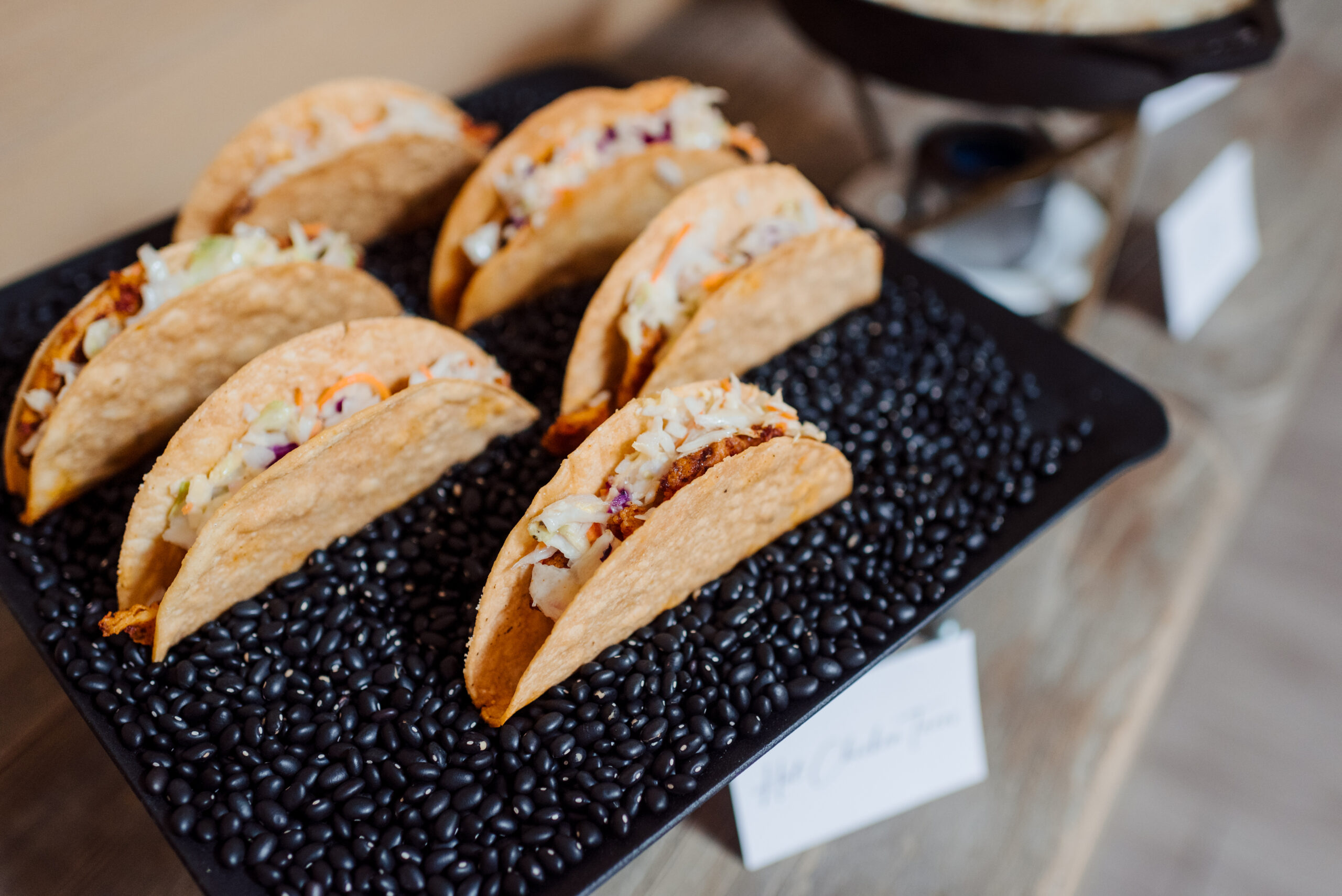 Pre-made hard shell tacos sitting on a display table