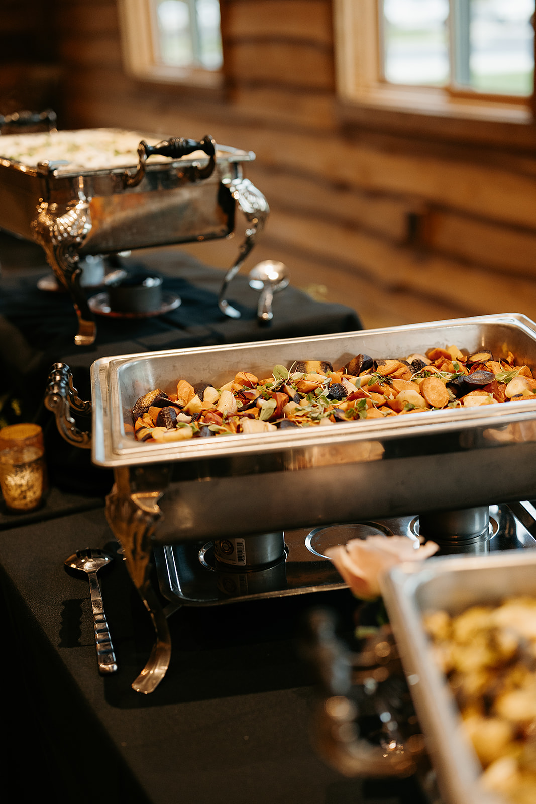 Sage and brown butter carrots in a buffet chafing dish lined up on the buffet table