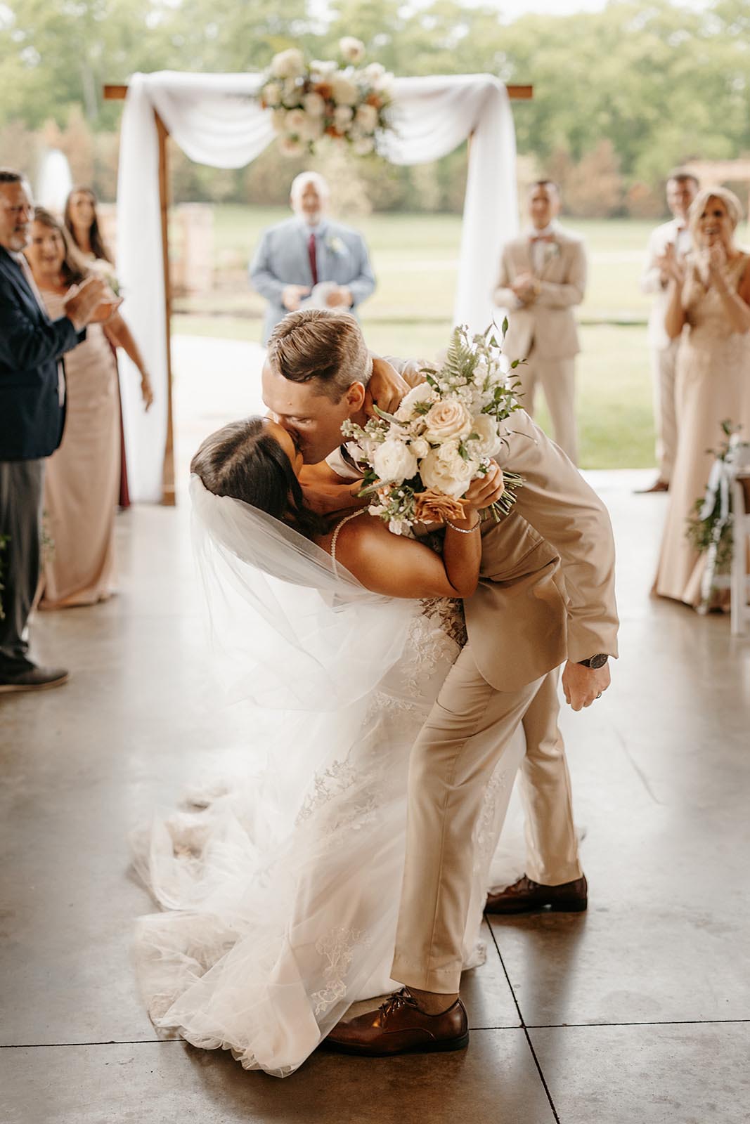 A groom dips his bride for a kiss as they leave their wedding ceremony during the recessional.