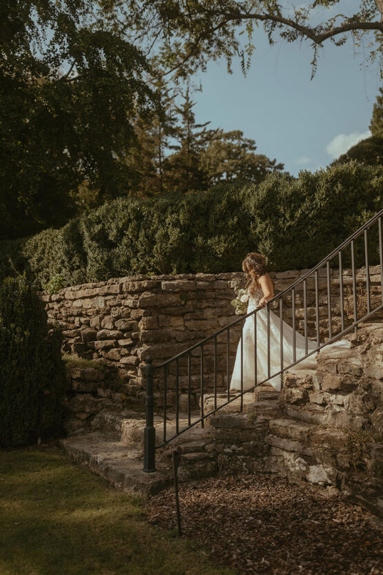 Bride walking down staircase at Cheekwood